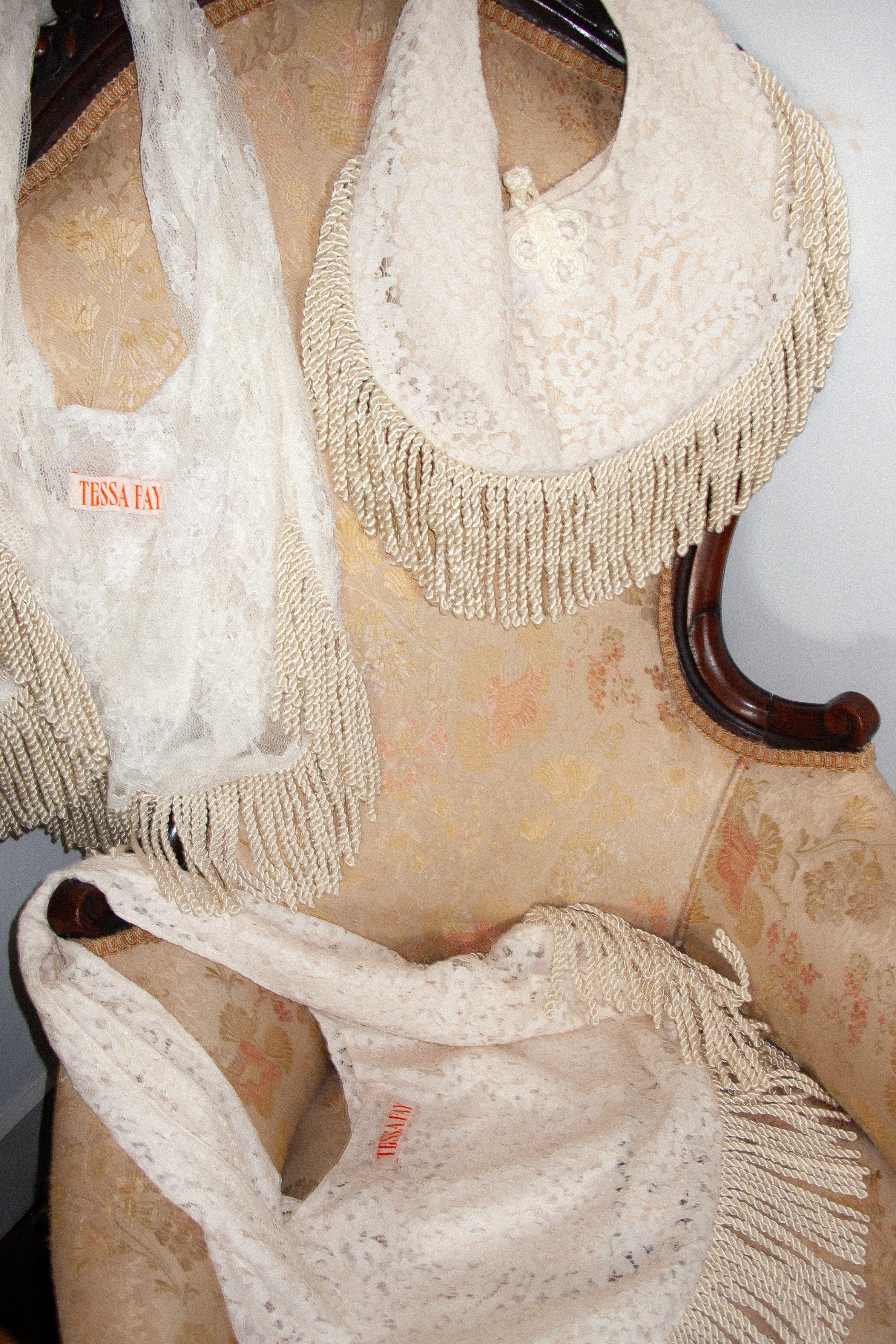 White lace bags with fringe on a wooden chair